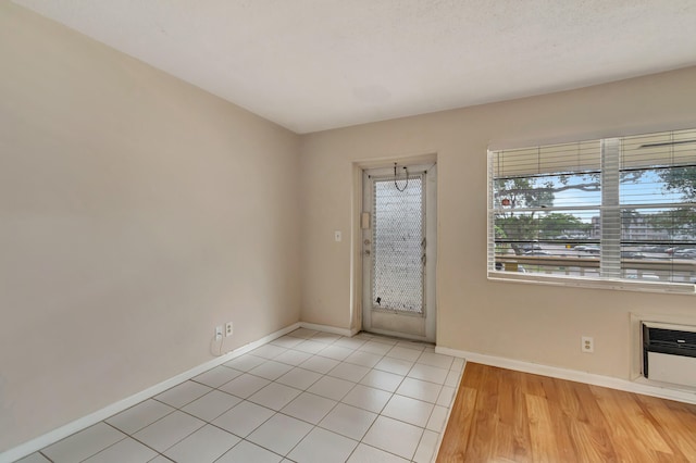 entrance foyer with a textured ceiling and light hardwood / wood-style floors