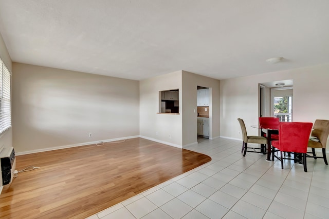 dining space featuring light wood-type flooring and a wall unit AC