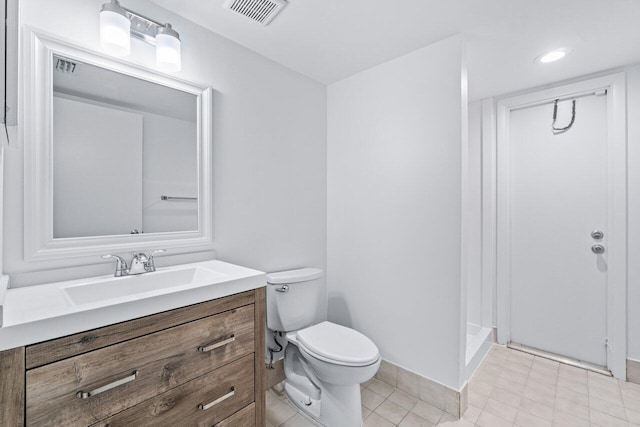 bathroom featuring vanity, toilet, and a shower