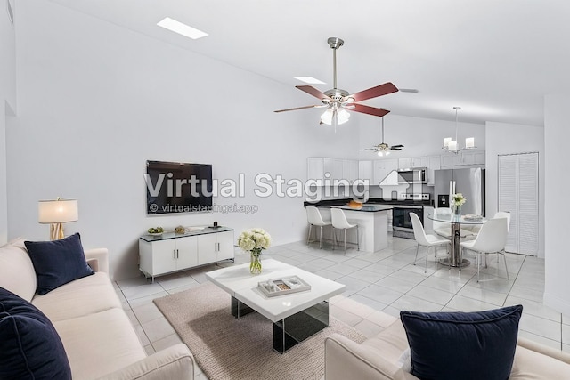 living room featuring high vaulted ceiling, ceiling fan, and light tile patterned flooring