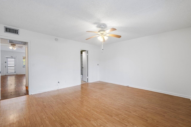 spare room with hardwood / wood-style flooring, ceiling fan, and a textured ceiling