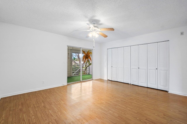 unfurnished bedroom featuring a textured ceiling, access to exterior, light wood-type flooring, and ceiling fan