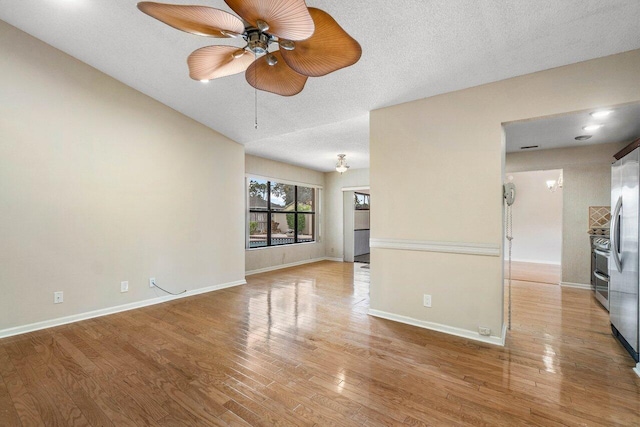 interior space featuring ceiling fan, light wood-type flooring, and a textured ceiling