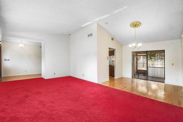 unfurnished room featuring a textured ceiling, light wood-type flooring, vaulted ceiling, and a notable chandelier