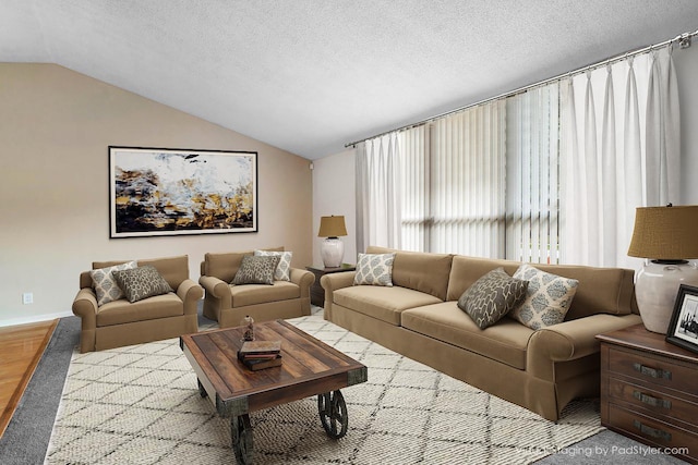 living room featuring vaulted ceiling and a textured ceiling