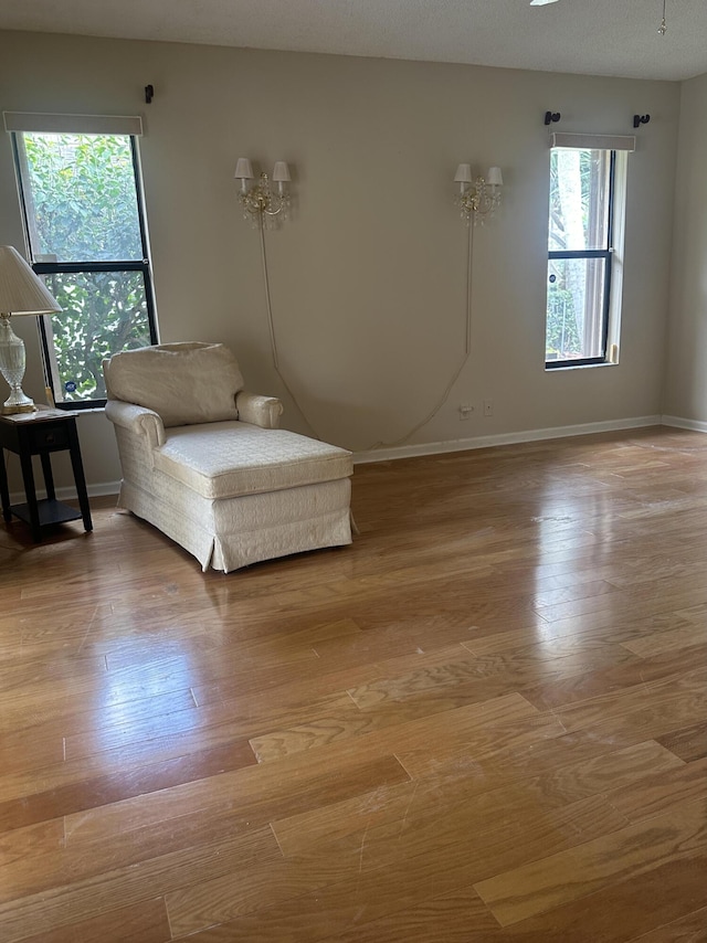 sitting room featuring baseboards and light wood finished floors