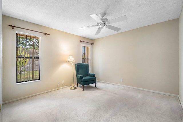 unfurnished room featuring a ceiling fan, light carpet, a textured ceiling, and baseboards