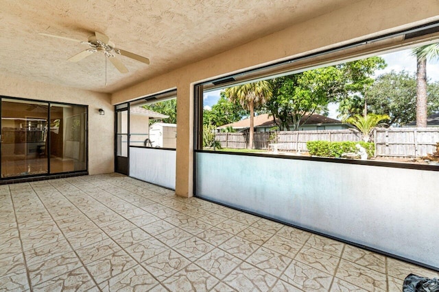 unfurnished sunroom featuring a ceiling fan