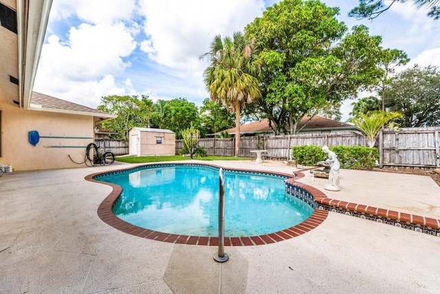 view of swimming pool featuring an outbuilding, a fenced backyard, a patio, and a shed