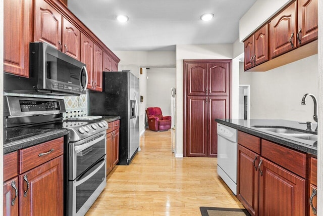 kitchen with appliances with stainless steel finishes, light hardwood / wood-style flooring, and sink