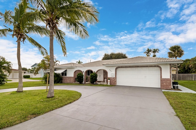 mediterranean / spanish-style house with a garage and a front yard