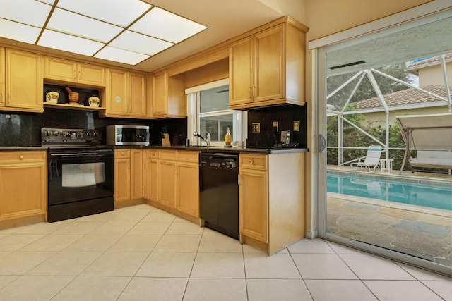 kitchen featuring light tile patterned floors, sink, backsplash, and black appliances