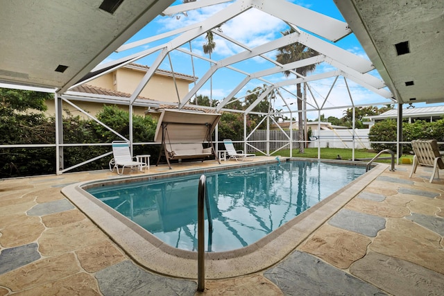 view of swimming pool with glass enclosure and a patio