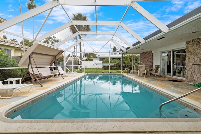 view of pool featuring a lanai, a patio area, and a storage unit