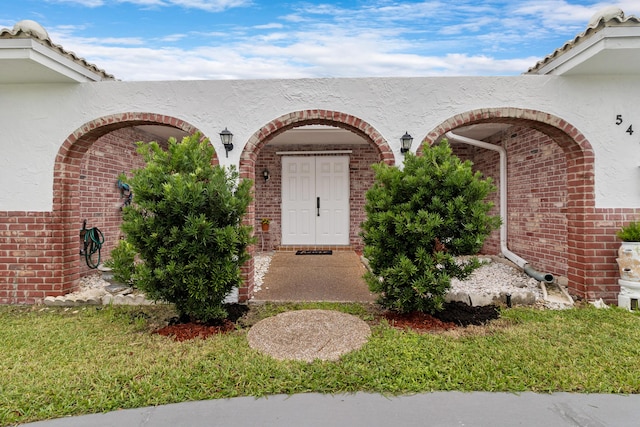 property entrance featuring a lawn