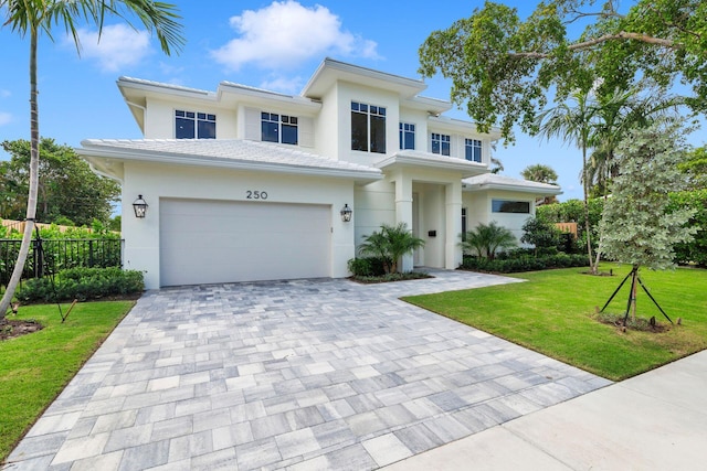 view of front of property with a front lawn, fence, decorative driveway, stucco siding, and an attached garage