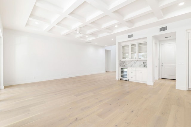 unfurnished living room with coffered ceiling, light hardwood / wood-style flooring, and beverage cooler