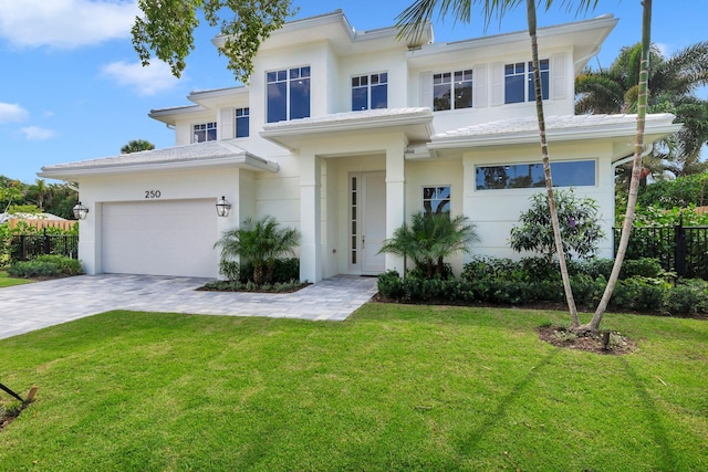 view of front of home featuring a garage, fence, a front yard, decorative driveway, and stucco siding