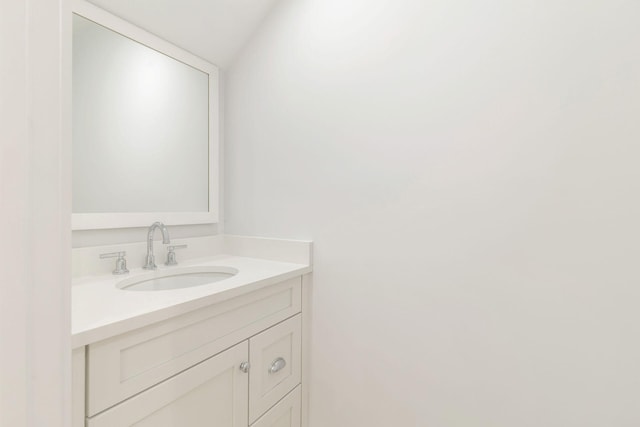 bathroom with vanity and vaulted ceiling