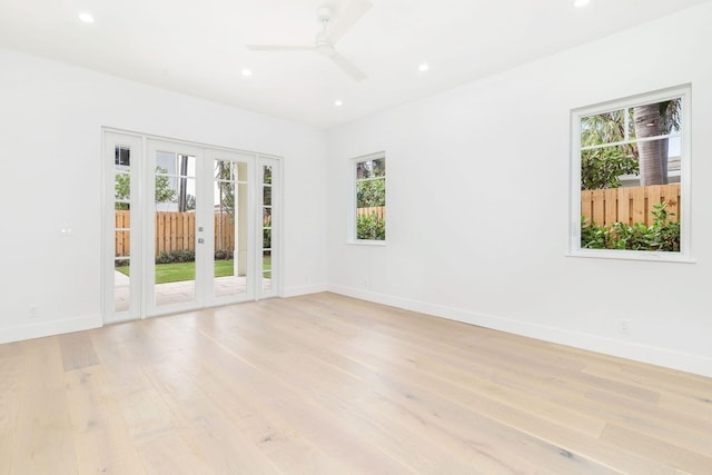 unfurnished room with baseboards, a ceiling fan, french doors, and light wood-style flooring