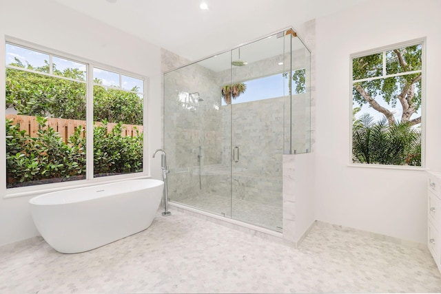 full bath with baseboards, a shower stall, and a soaking tub