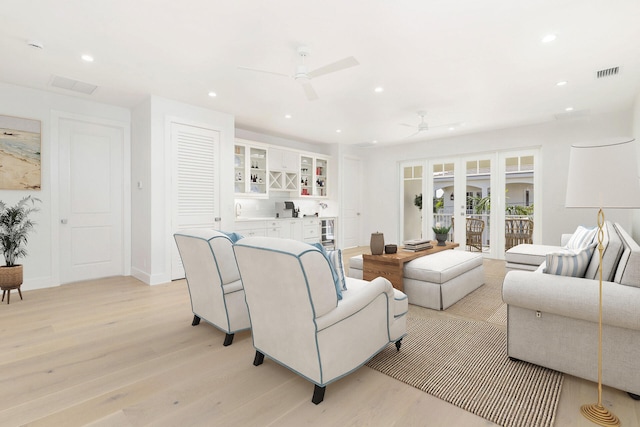 living room featuring french doors, light hardwood / wood-style floors, and ceiling fan