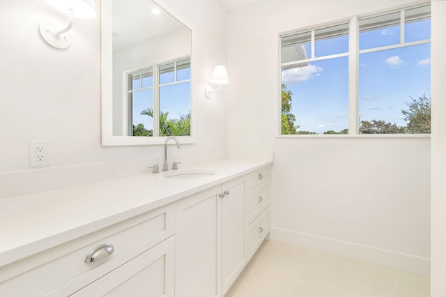 bathroom with plenty of natural light, baseboards, and vanity