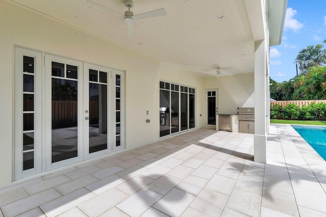 view of patio with grilling area, french doors, exterior kitchen, fence, and a fenced in pool
