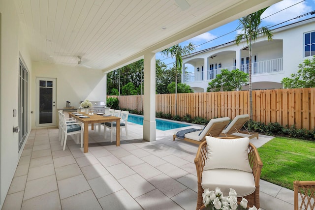 view of patio / terrace featuring a balcony, an outdoor kitchen, area for grilling, and a fenced in pool