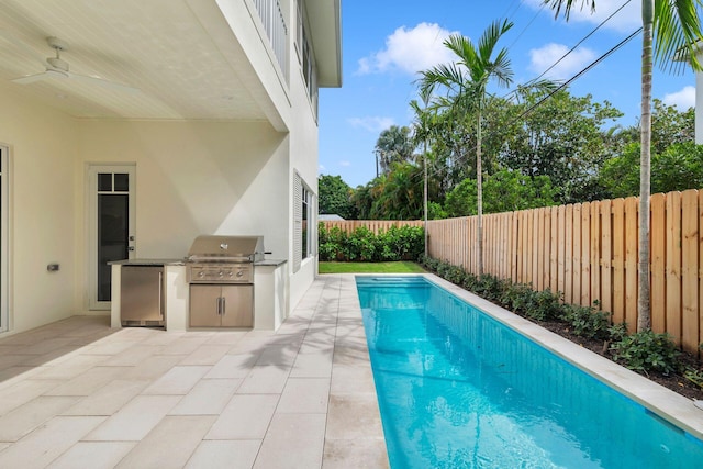 view of swimming pool featuring a patio area, area for grilling, and a grill