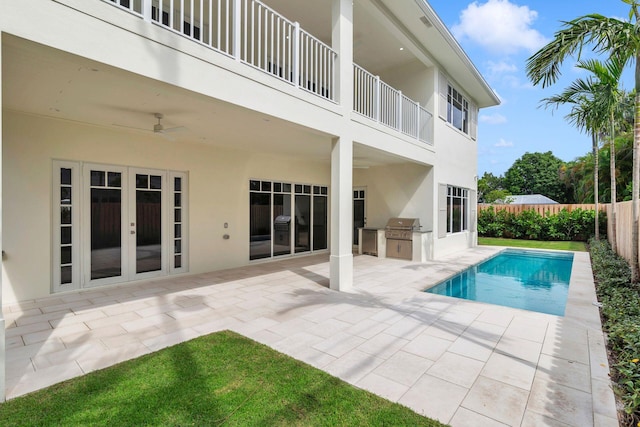 view of pool featuring a patio area, french doors, grilling area, exterior kitchen, and ceiling fan