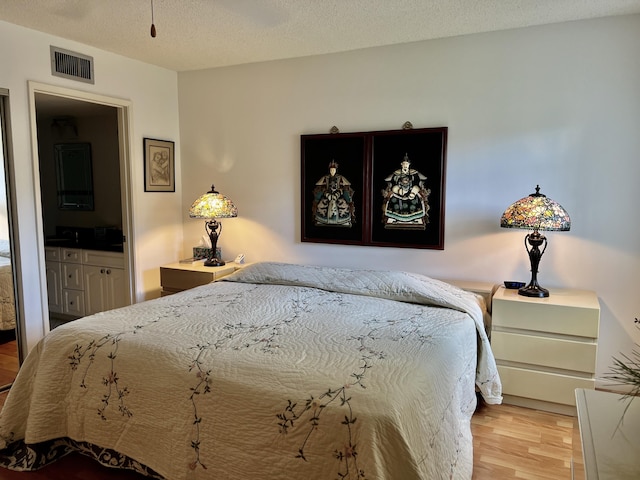 10915 Palm Lake Ave Unit 102, Boynton Beach, FL 33437 - bedroom featuring wood finished floors, a textured ceiling, and visible vents
