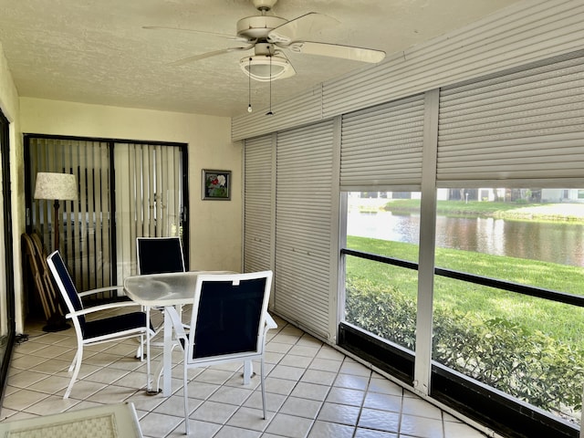 unfurnished sunroom with a water view and a ceiling fan