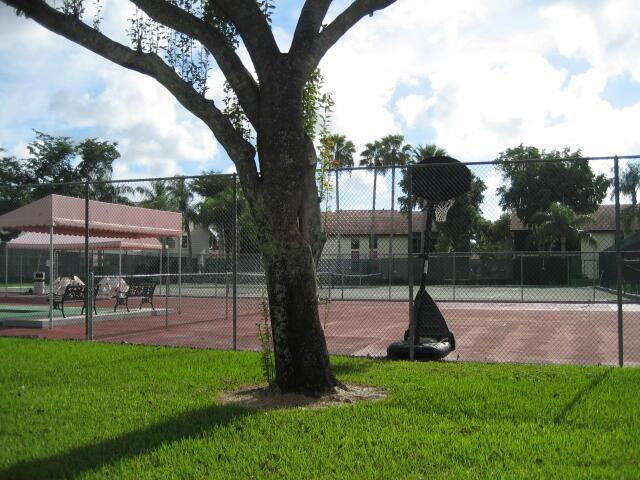 view of sport court with a yard and fence