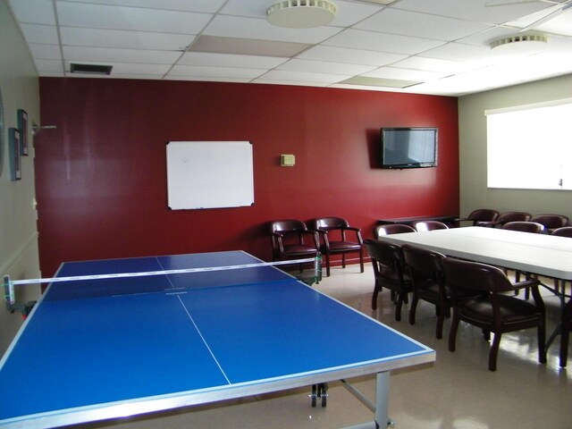 carpeted dining area with track lighting and a drop ceiling