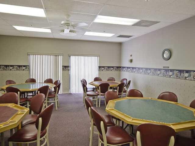 carpeted dining area with visible vents, a drop ceiling, and a ceiling fan