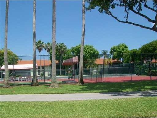 view of sport court with a lawn