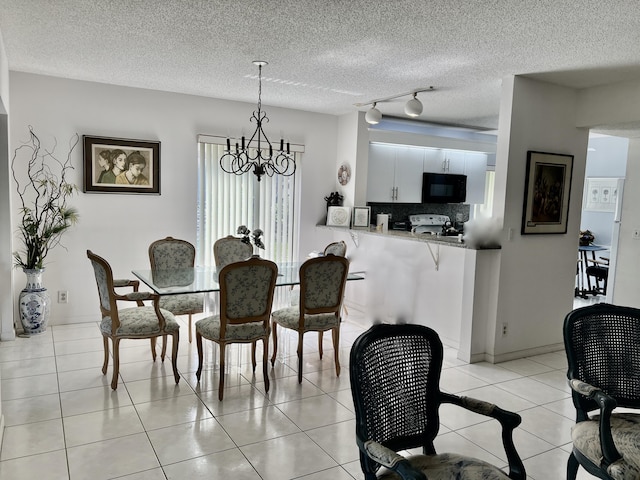 dining space with light tile patterned floors, a textured ceiling, a chandelier, baseboards, and rail lighting