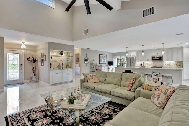 living room with a high ceiling and ceiling fan