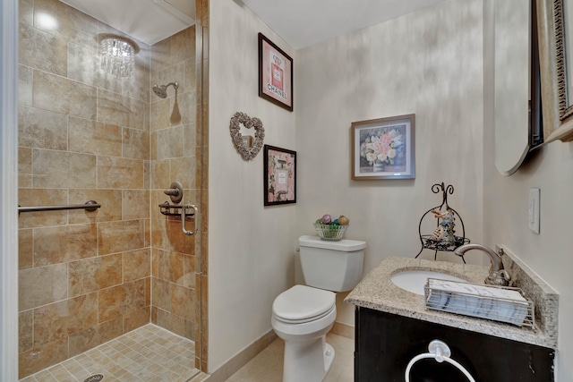 bathroom featuring vanity, toilet, tiled shower, and tile patterned flooring