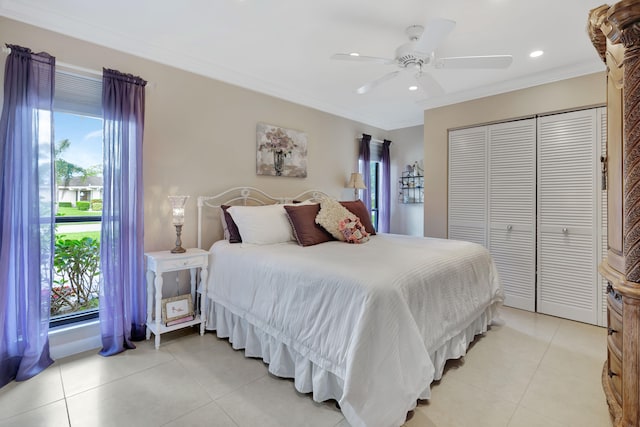 bedroom with a closet, ceiling fan, ornamental molding, and light tile patterned floors