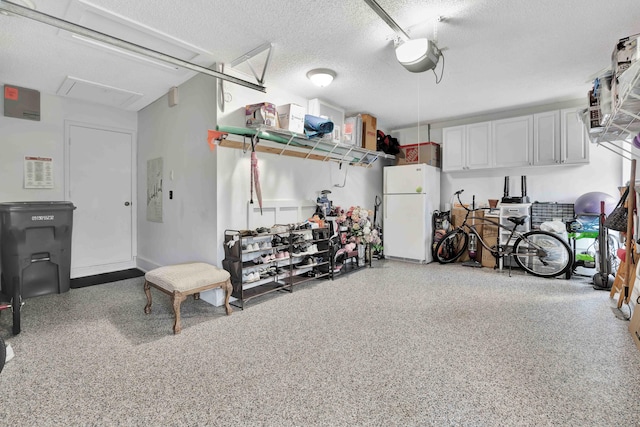 garage with white fridge and a garage door opener