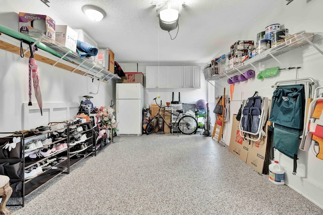 garage with a garage door opener and white refrigerator