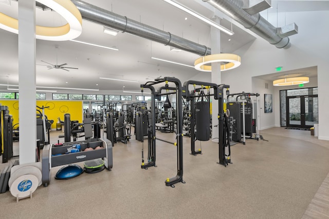 gym with ceiling fan and a high ceiling