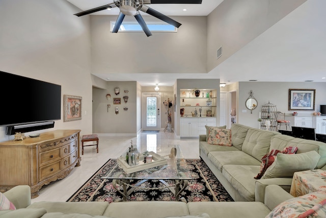 living room featuring ceiling fan and a high ceiling