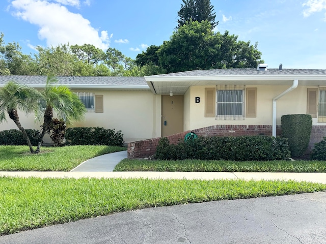 single story home featuring a front lawn