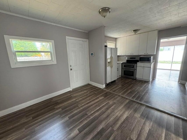 kitchen featuring appliances with stainless steel finishes, a healthy amount of sunlight, white cabinetry, and dark hardwood / wood-style floors