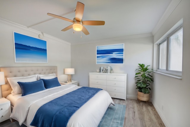 bedroom featuring crown molding, light wood-type flooring, and ceiling fan