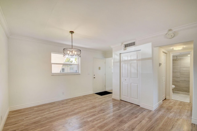 unfurnished room with light hardwood / wood-style floors, crown molding, and an inviting chandelier