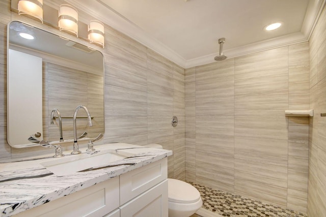 bathroom featuring toilet, vanity, crown molding, tile walls, and walk in shower